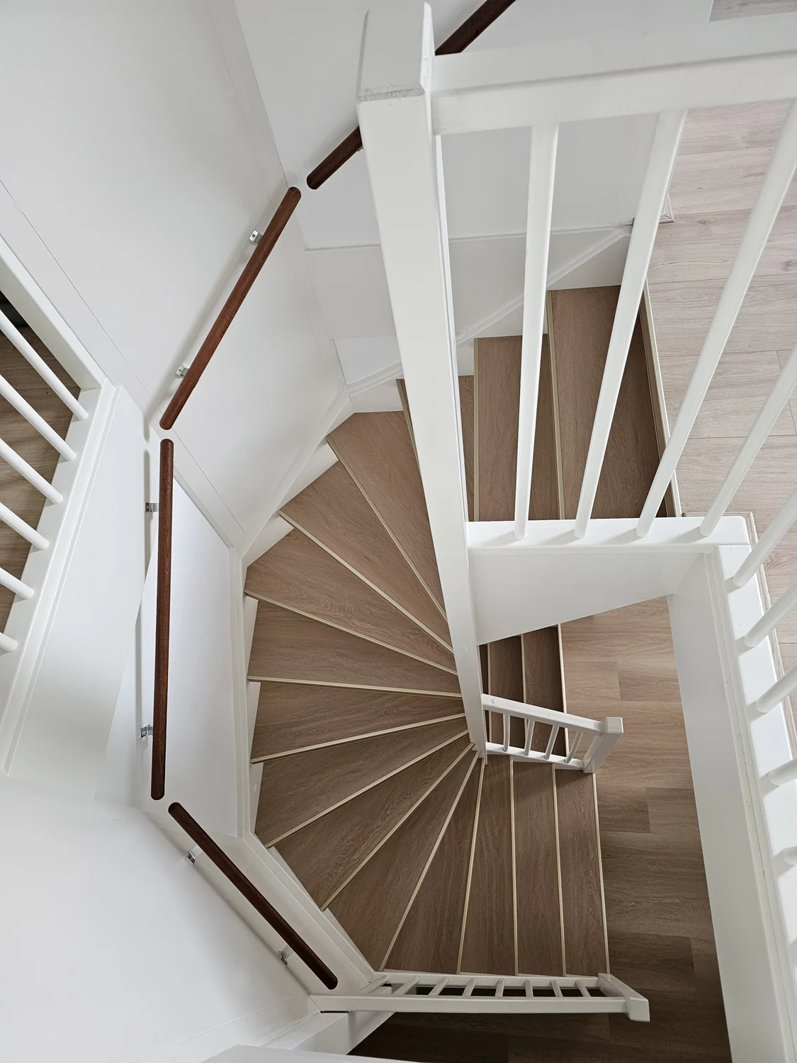 Trap met lichte houten treden en een witte balustrade